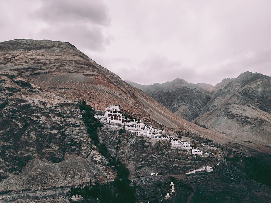 White Concrete Buildings on Rock Mountain Under Gray Sky, architecture HD wallpaper