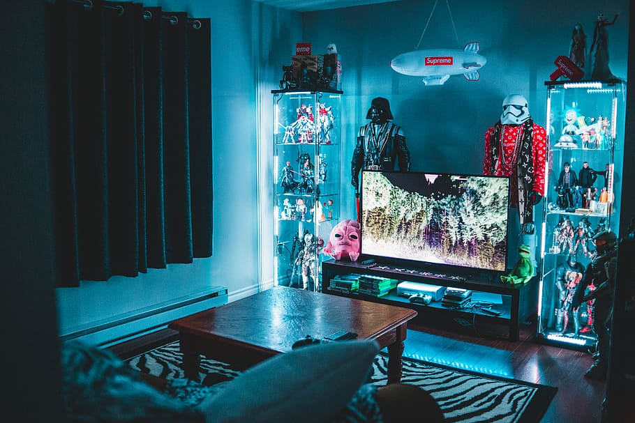 turned on flat screen TV surrounded by Star Wars figures, room