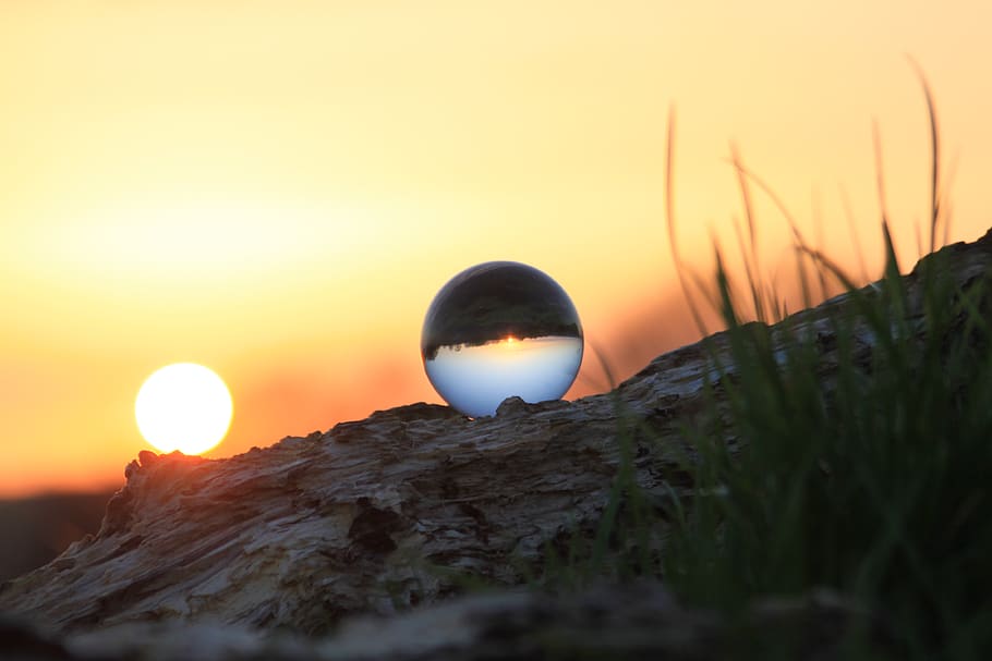 Photography of Glass Ball on Brown Rock Formation during Sunset HD wallpaper