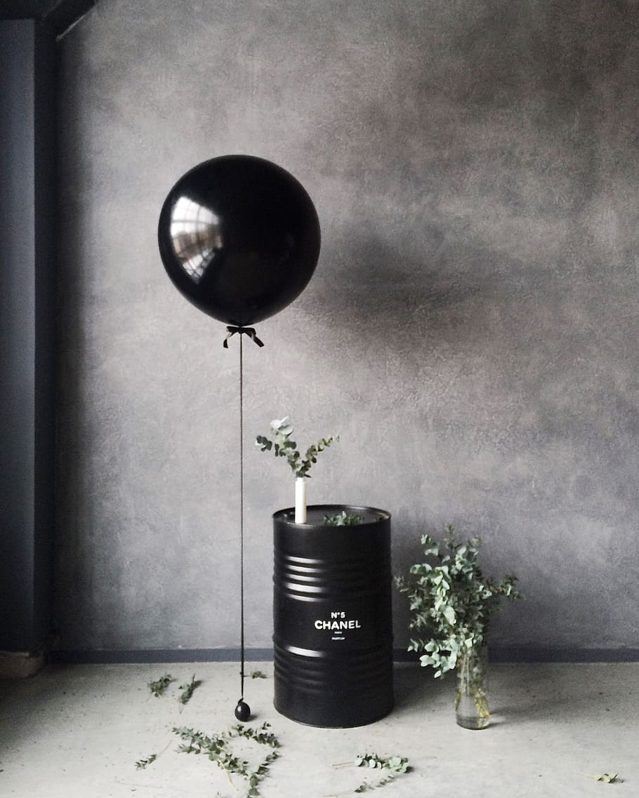 Grayscale Photography of Balloon Beside Chanel Metal Barrel, black