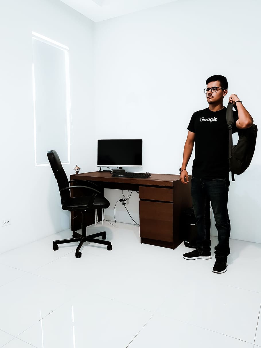 man standing near brown desk beside white wall, person, office HD wallpaper