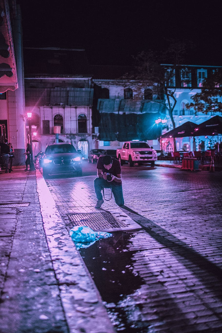 Person Taking Photo of Ground in Front of Vehicle during Night