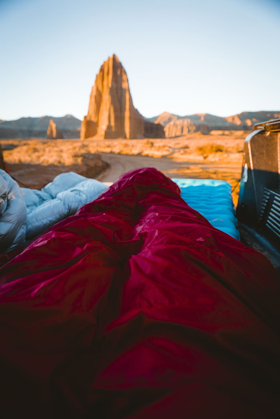 person in sleeping bag overlooking rock formations, nature, capitol reef national park