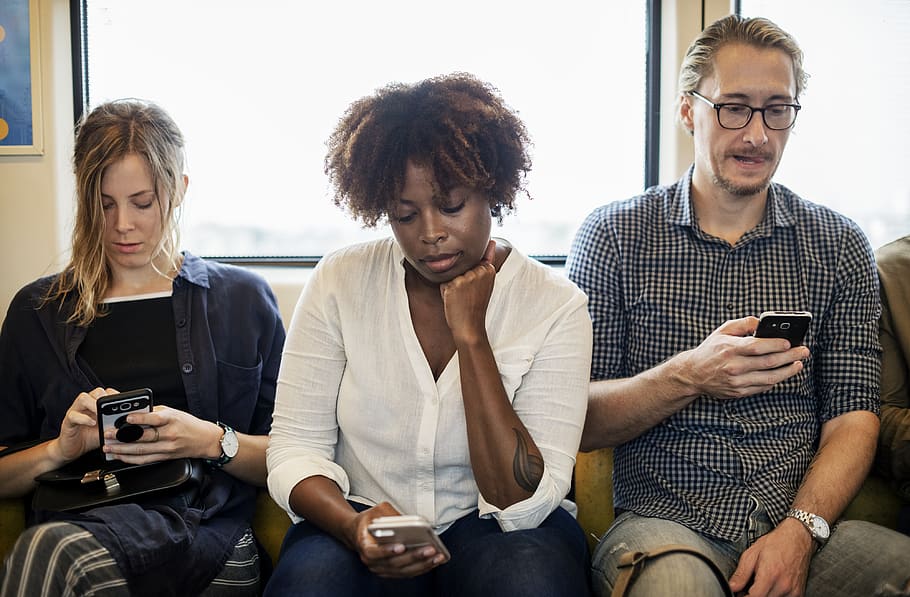 Two Women and One Man Sitting in Front of Window Using Smartphones HD wallpaper