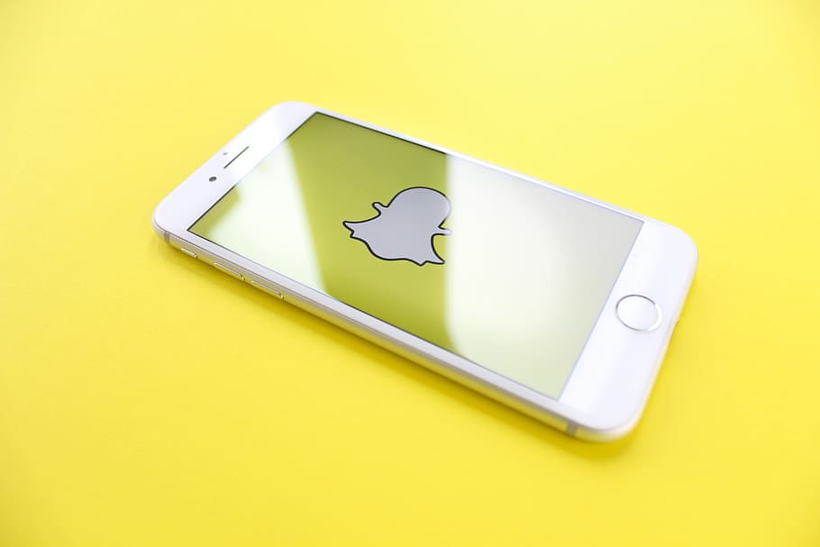 silver iPhone 6 on top of yellow wooden surface, snapchat, smartphone