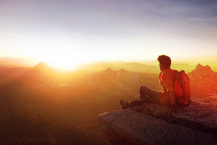 Man Sitting on Edge Facing Sunset, adult, adventure, backlit