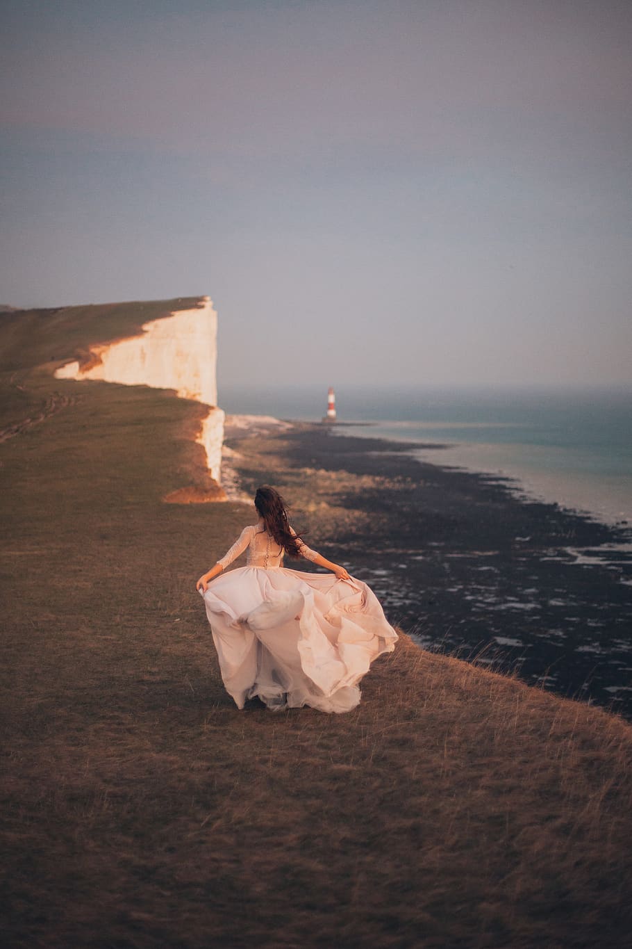 Woman Walking Near Body of Water, beach, cliff, cliff coast, clouds HD wallpaper