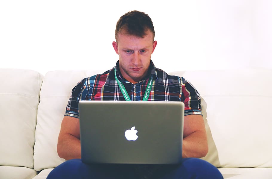 Man Using Macbook While Sitting on White Sofa, adult, apple, coder HD wallpaper