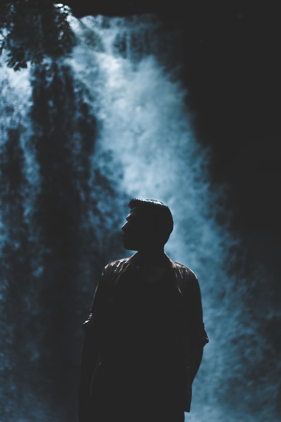 silhouette of man with rushing waterfalls on background, male