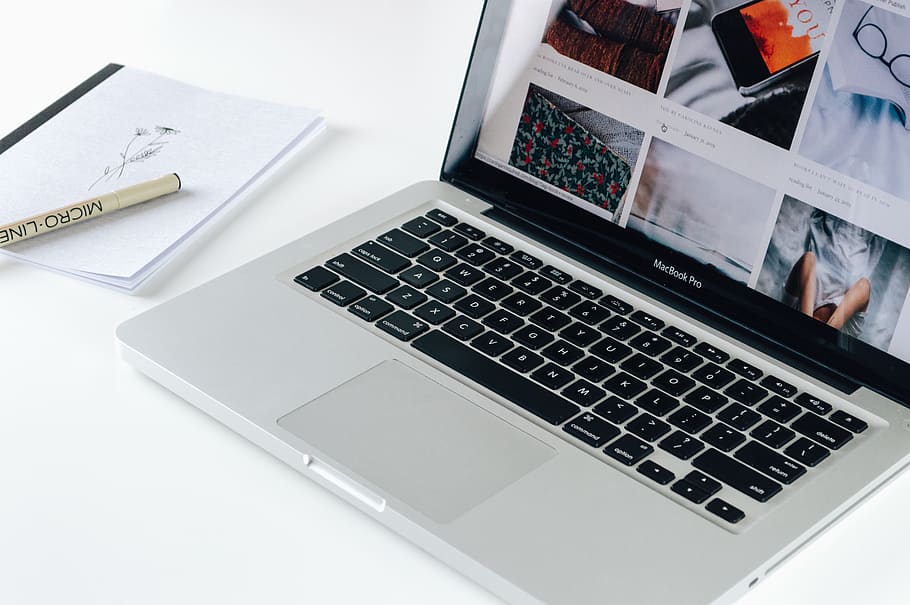Macbook Pro besides white book, laptop, technology, wireless technology HD wallpaper