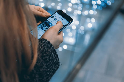 Young girl uses smartphone with Instagram app, wireless technology HD wallpaper