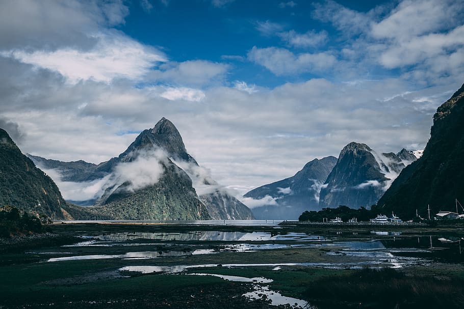 Surrounded by mountains. Данидин - Милфорд саунд. Milford (8 штук). Фьорд Милфорд саунд 19 век. Небо горы и деревня Unsplash.