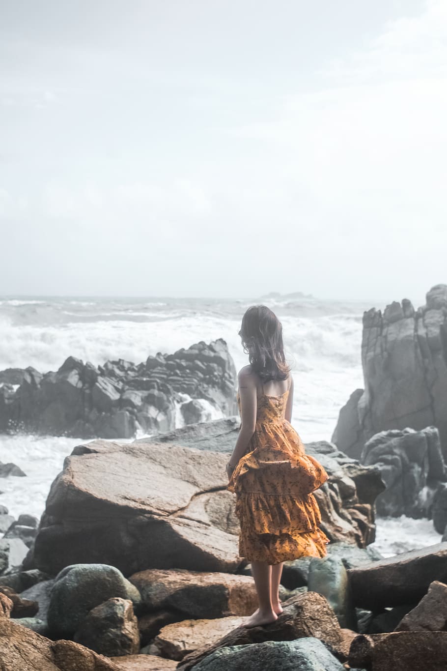 Woman in Orange Dress Standing on Rock Groynes, beach, clouds HD wallpaper