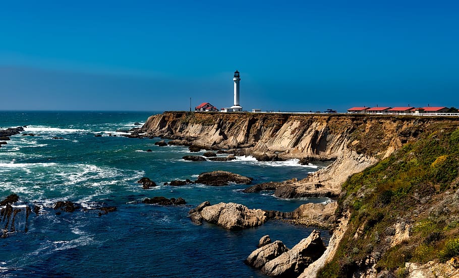 White Lighthouse Near Body of Water Under Blue Sky during Daytime HD wallpaper