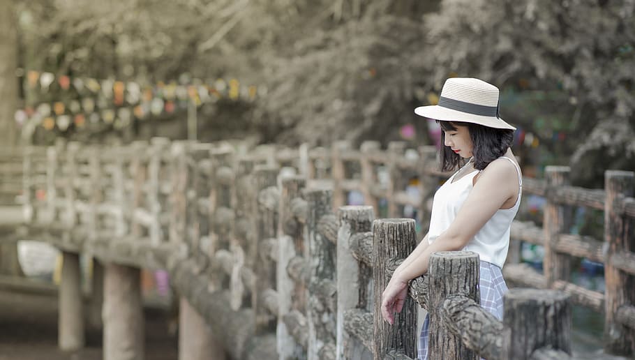 Woman Wearing White Tank Top and White Hat Standing on a Boardwalk HD wallpaper