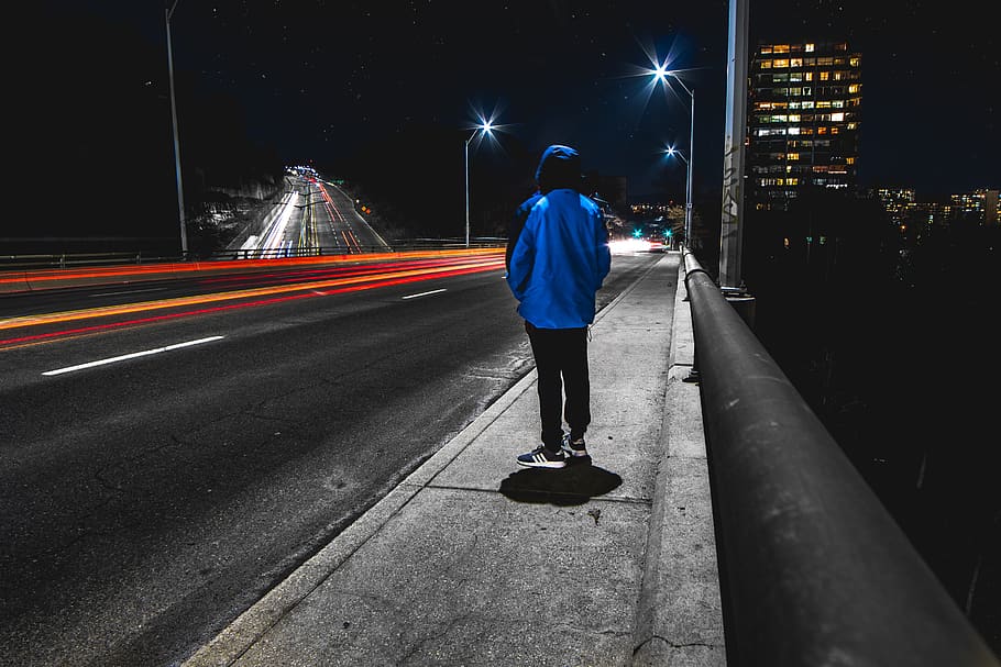 time lapse photography of person standing on street during nighttime