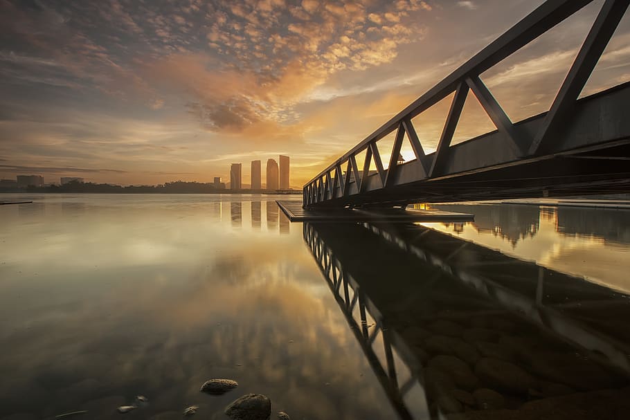 Bridge on Body of Water Near High-rise Building during Golden Hour HD wallpaper