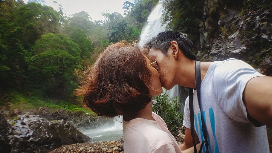 Man Kissing Woman Behind Waterfalls, affection, couple, daylight HD wallpaper