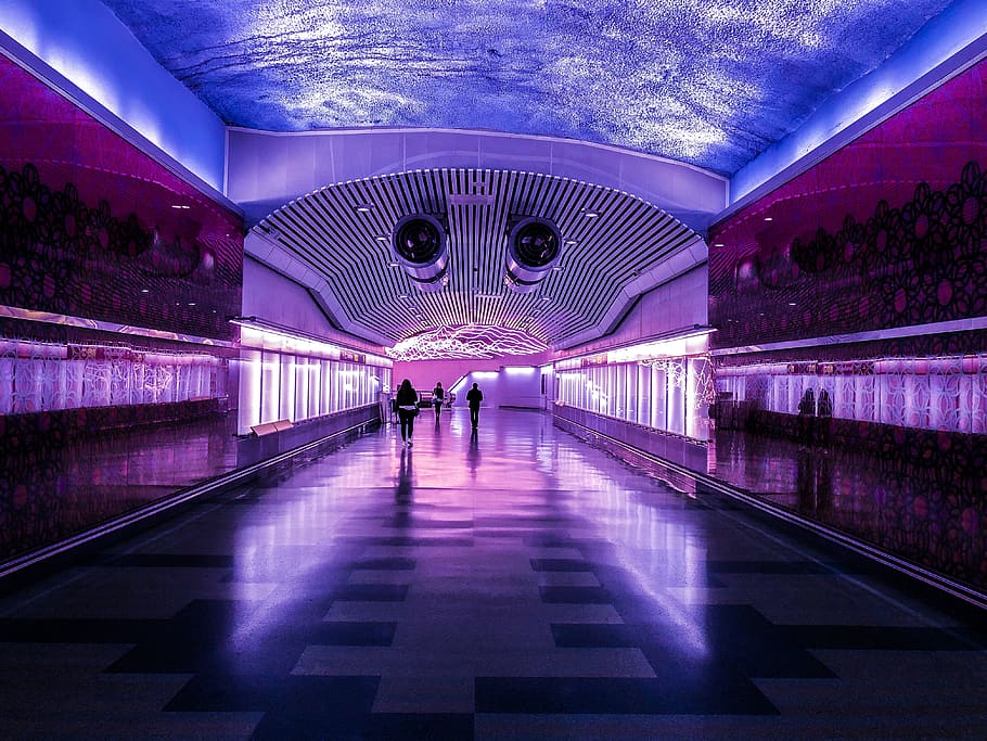 people walking in building with purple and blue lights, lighting