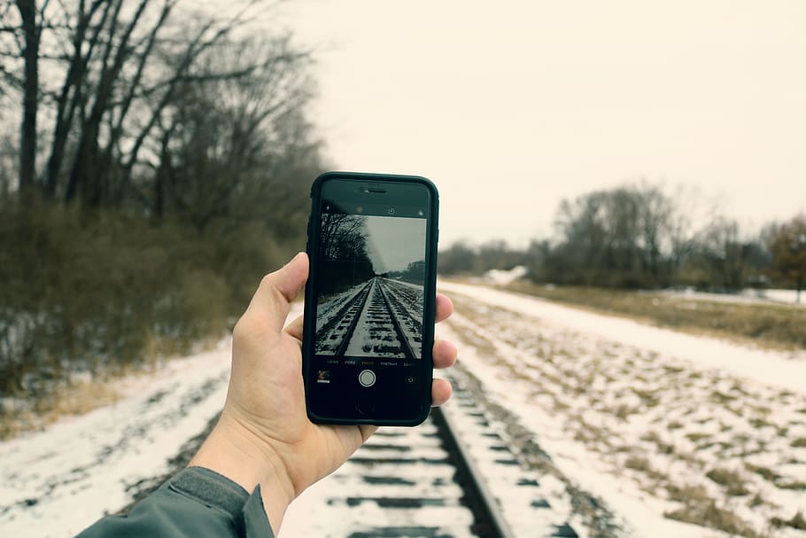 Person Holding Iphone Taking Photo of Train Rails, blur, cellular telephone HD wallpaper