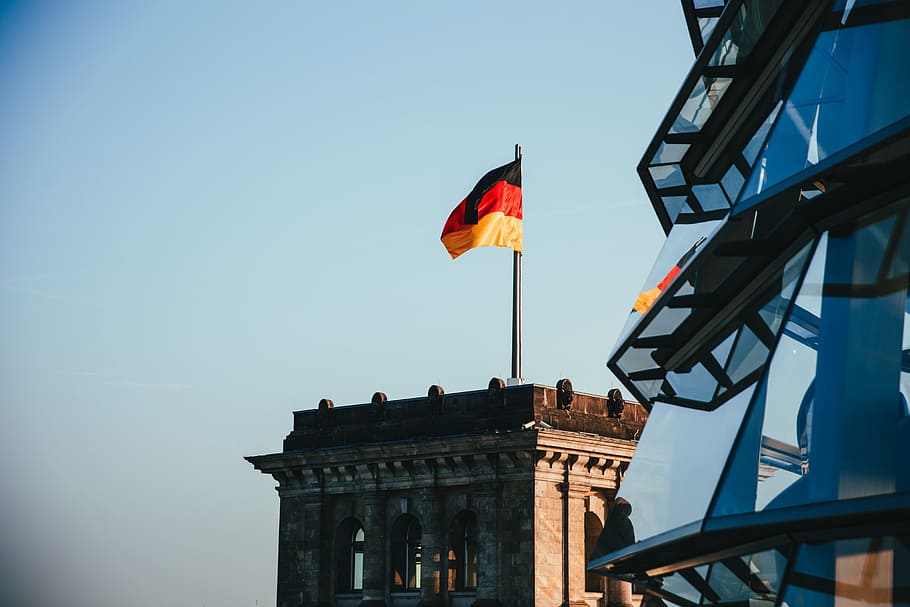 German flag fluttering on a rooftop in sunshine, architecture