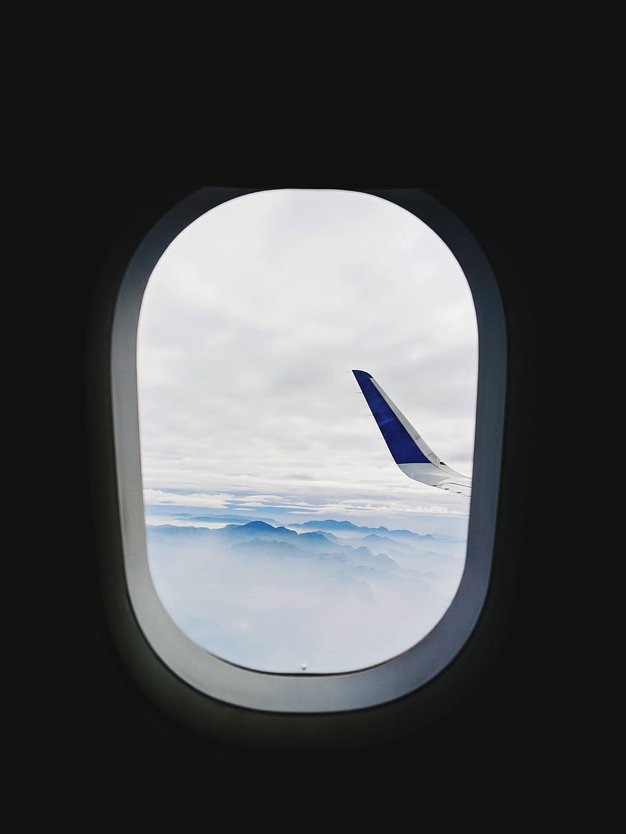 blue painted airliner wing tip seen through window, airplane