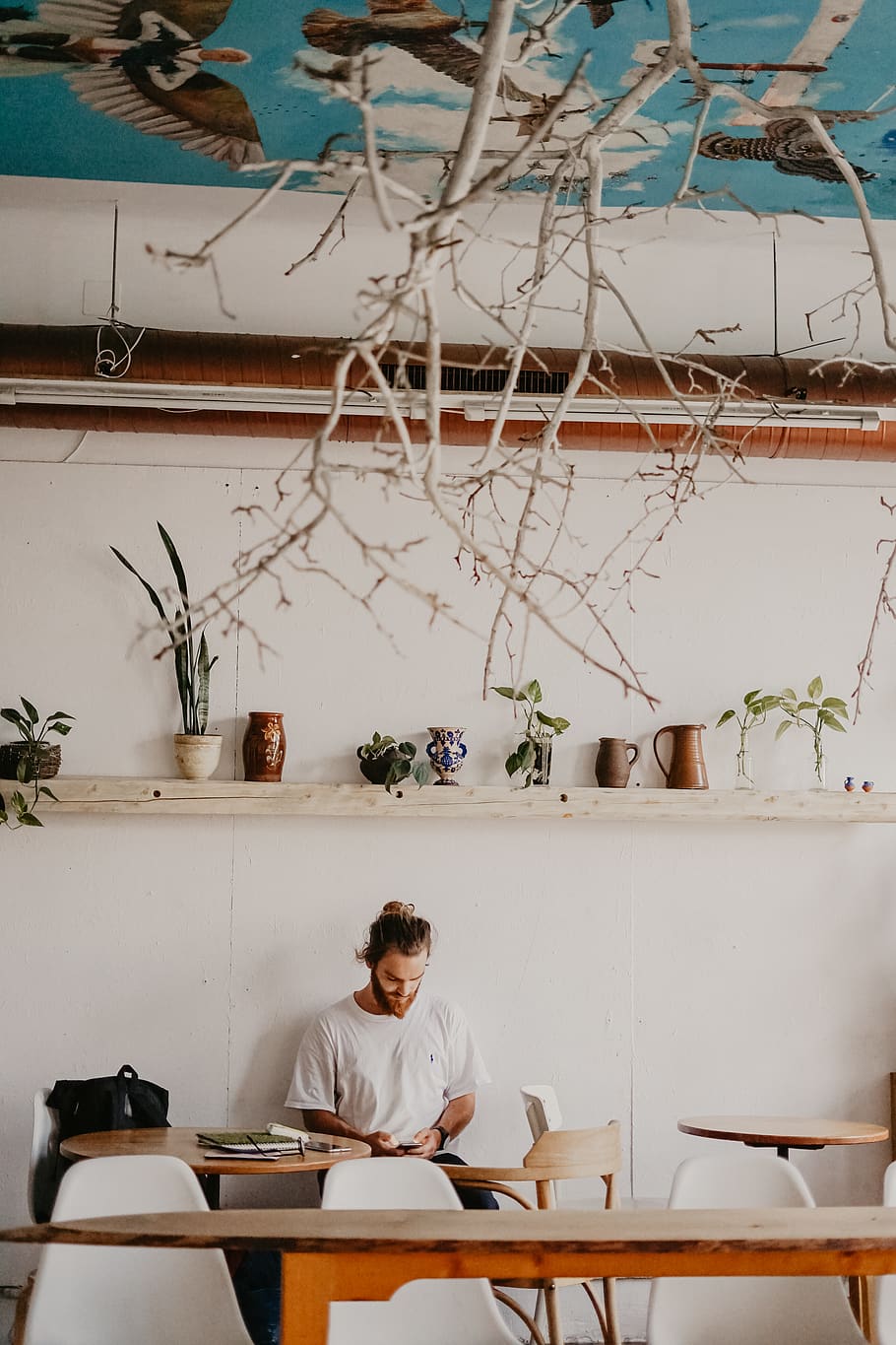 man standing beside painted wall, sitting, real people, one person HD wallpaper