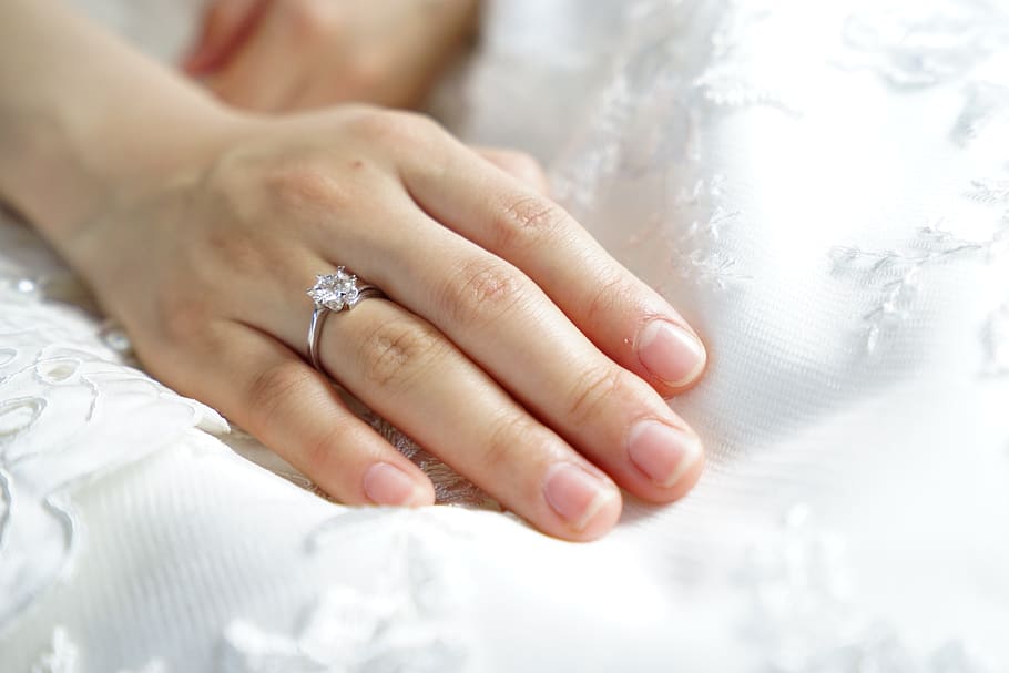 Person Wearing Silver-colored Solitaire Ring With Clear Gemstone