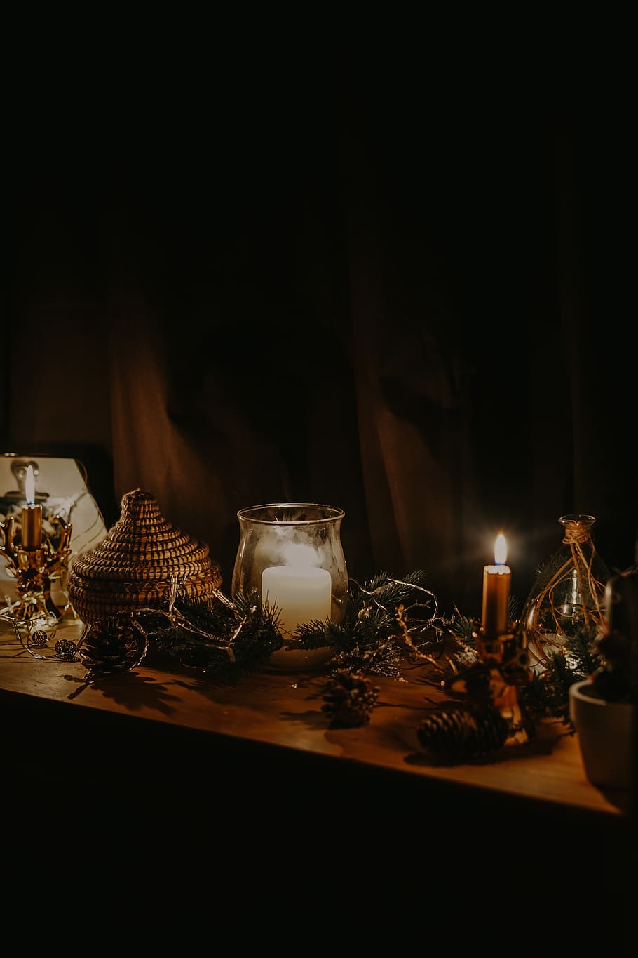 lighted candle near jars and pine cone on table, lighting, building