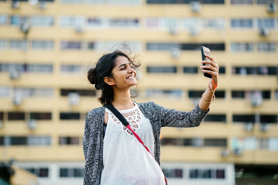 Smiling Woman Holding Black Smartphone, beautiful, blurred background HD wallpaper