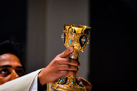 priest raising gold-colored chalice, human, person, wristwatch HD wallpaper