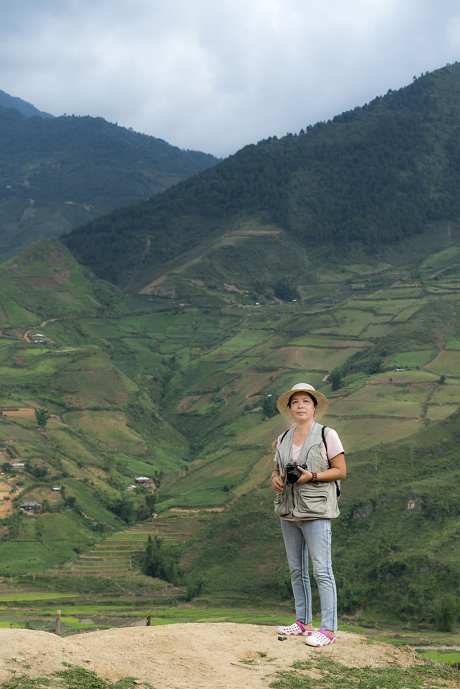 Woman Holding Camera In Front Of Green Mountain, cropland, environment HD wallpaper