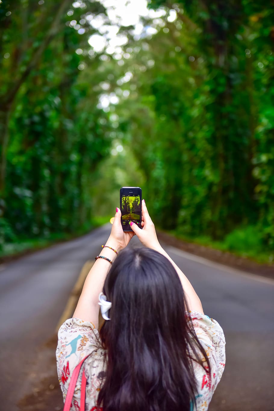Woman Holding Smartphone on Street Between Trees, back view, blur HD wallpaper