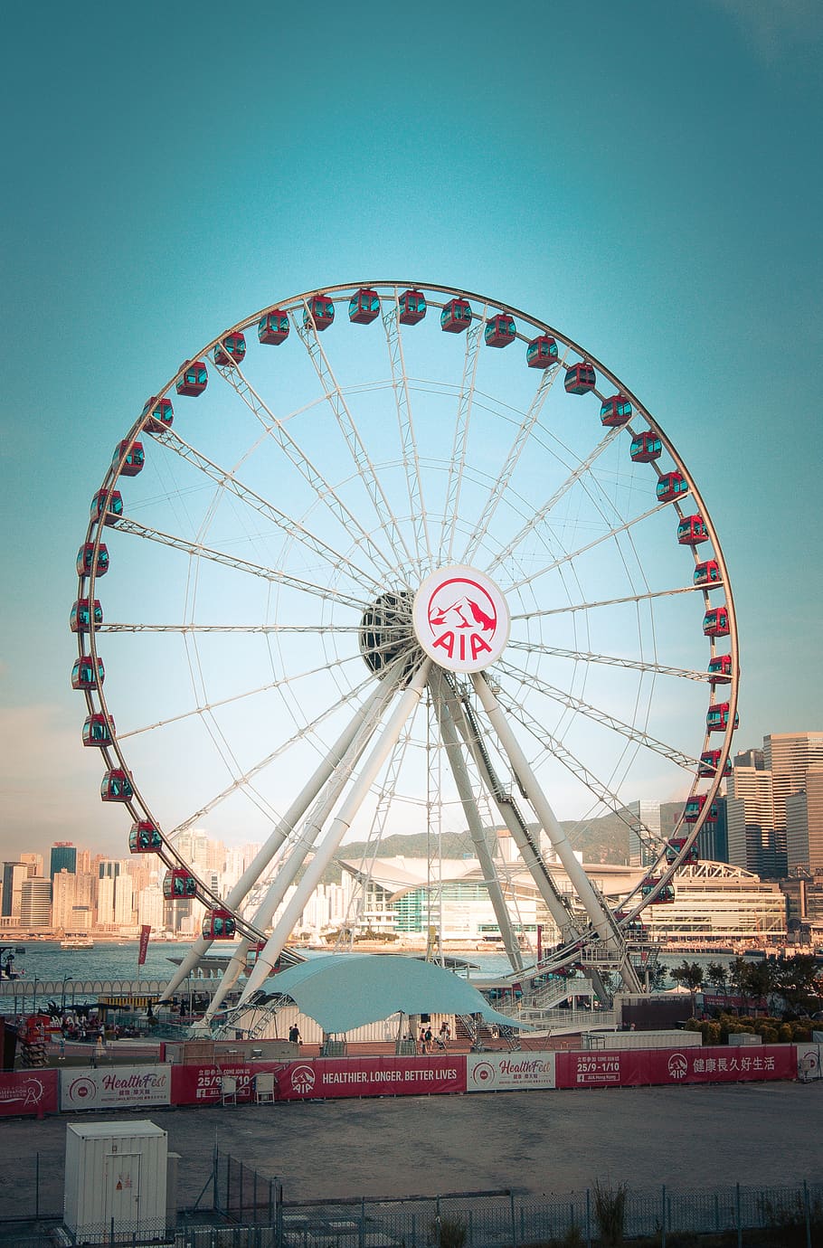 white Aia ferris wheel near body of water and building during daytime