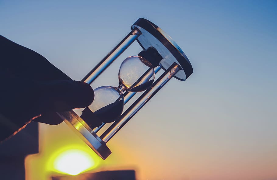 sunset, man, hand, blur, action, dusk, hourglass, hours, illuminated HD wallpaper