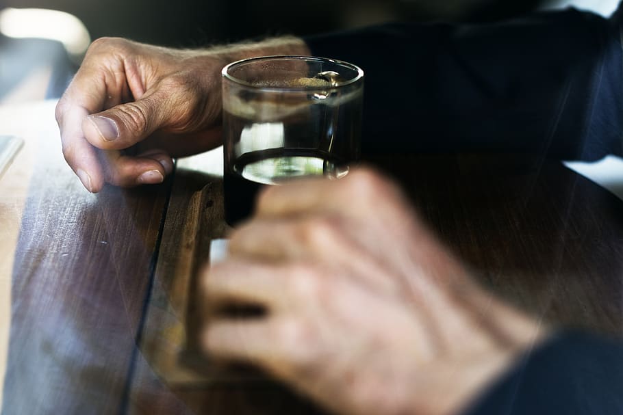 Man in Blue Long Sleeve Shirt In Front Of Drinking Glass On Brown Wooden Table HD wallpaper