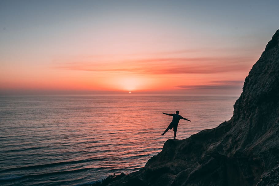 Man on Cliff, adventure, backlit, beach, beautiful, dawn, dusk HD wallpaper