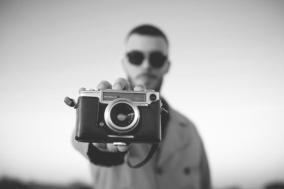 man standing and showing bridge camera, person, human, accessories HD wallpaper