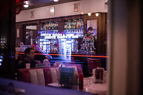 man sitting inside store during night time, person, human, pub HD wallpaper