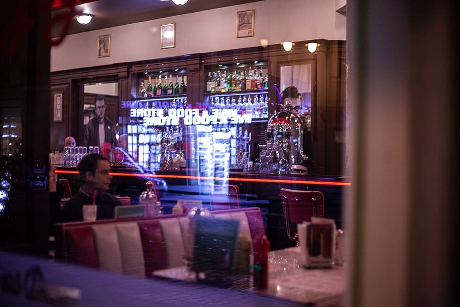 man sitting inside store during night time, person, human, pub HD wallpaper