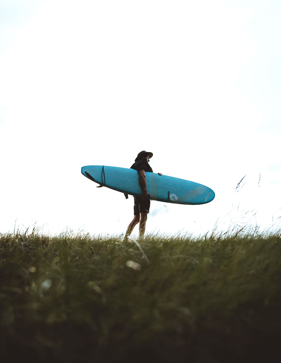 man holding teal surfboard at daytime, person, grass, beach, surfer HD wallpaper