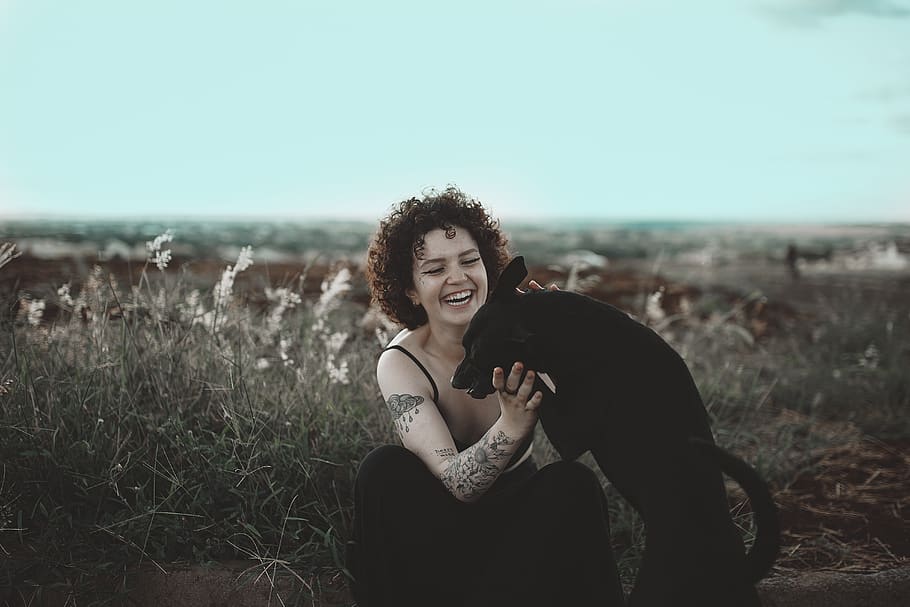 Photo of Smiling Woman Petting Black Dog, animal lover, brunette