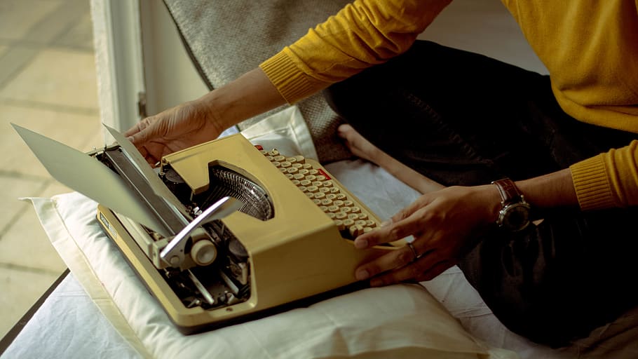 person using yellow typewriter, indoors, midsection, holding HD wallpaper