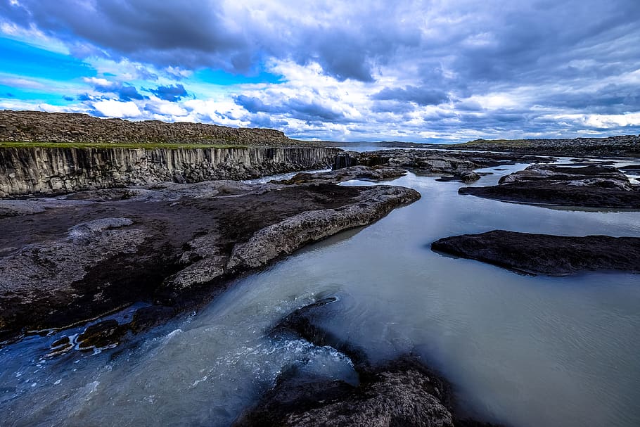 gray rock on river under cloudy sky, nature, outdoors, promontory HD wallpaper
