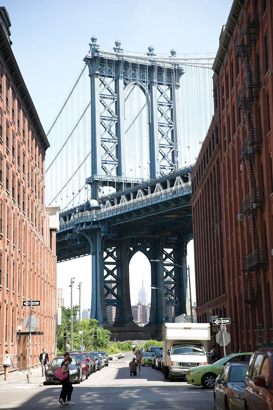 A view of Manhattan Bridge from a busy neighbourhood in a street HD wallpaper
