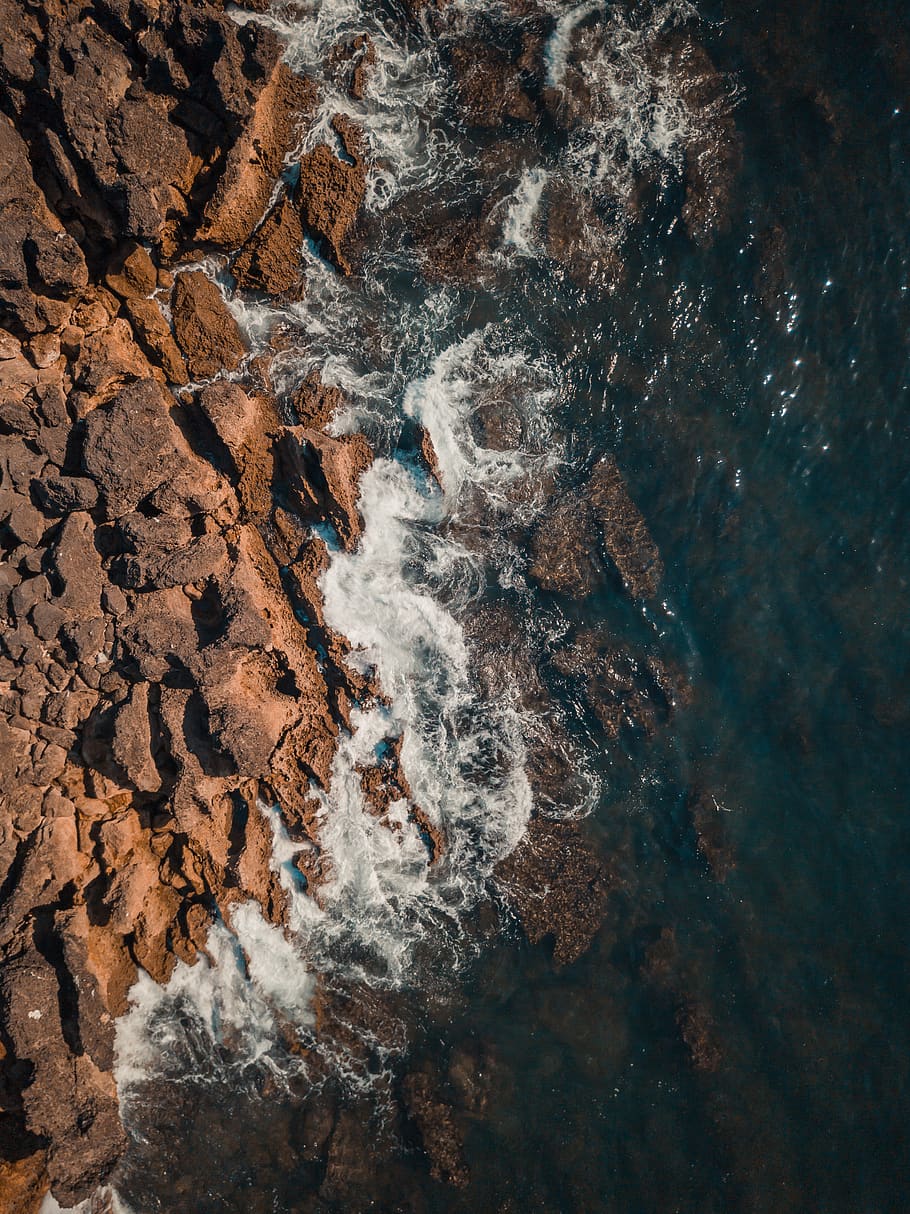 rocks beside body of water in aerial photo, outdoors, sea, sea waves