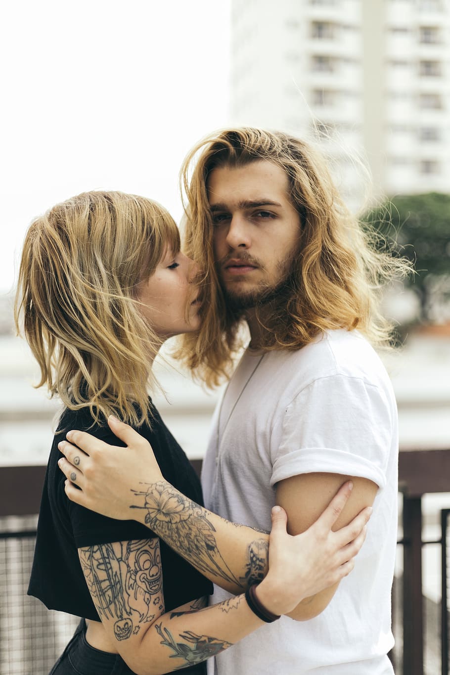 Man and Woman Facing Each Other Outside, blond hair, blurred background