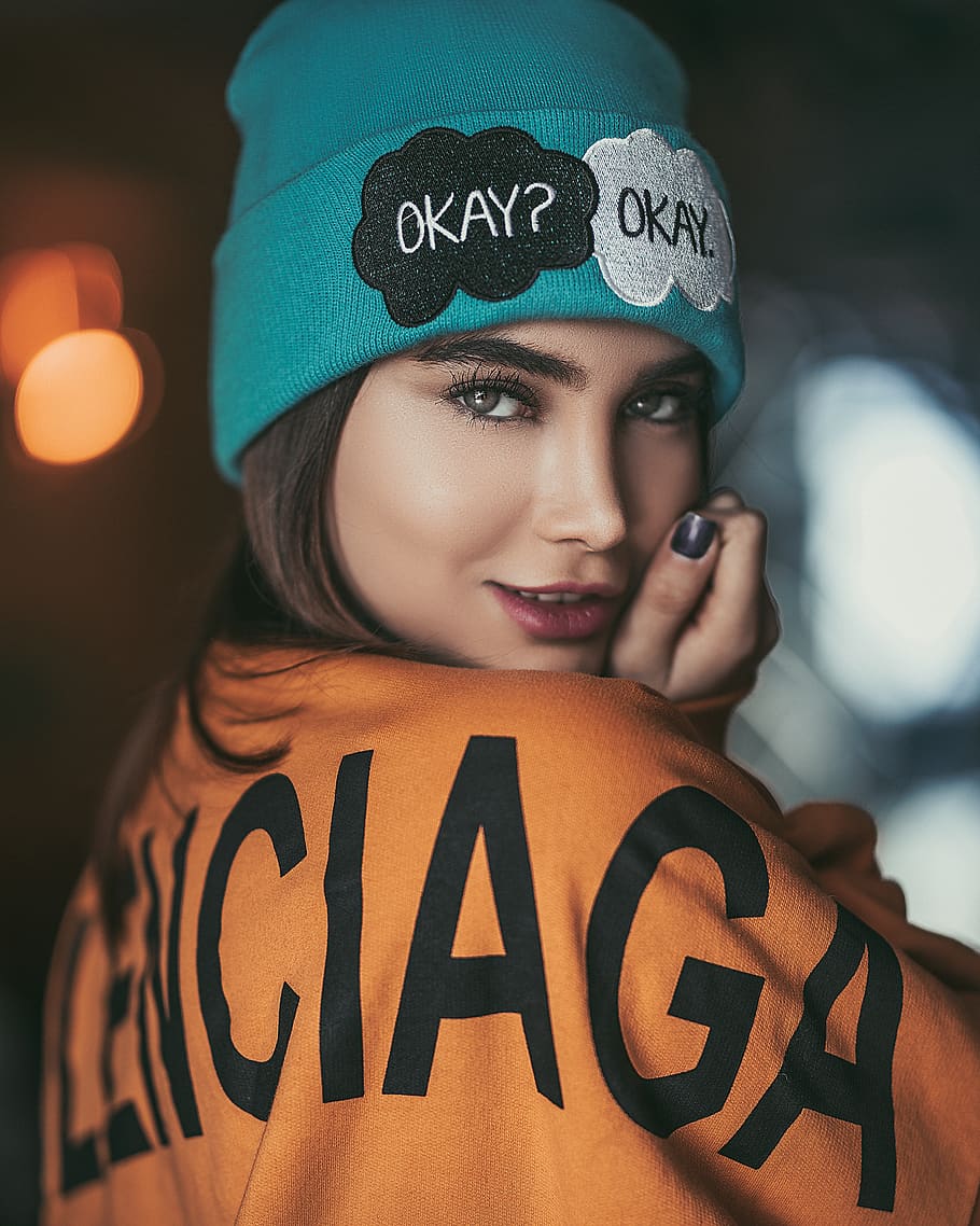 woman wearing orange and black sweater and teal beanie smiling, HD wallpaper