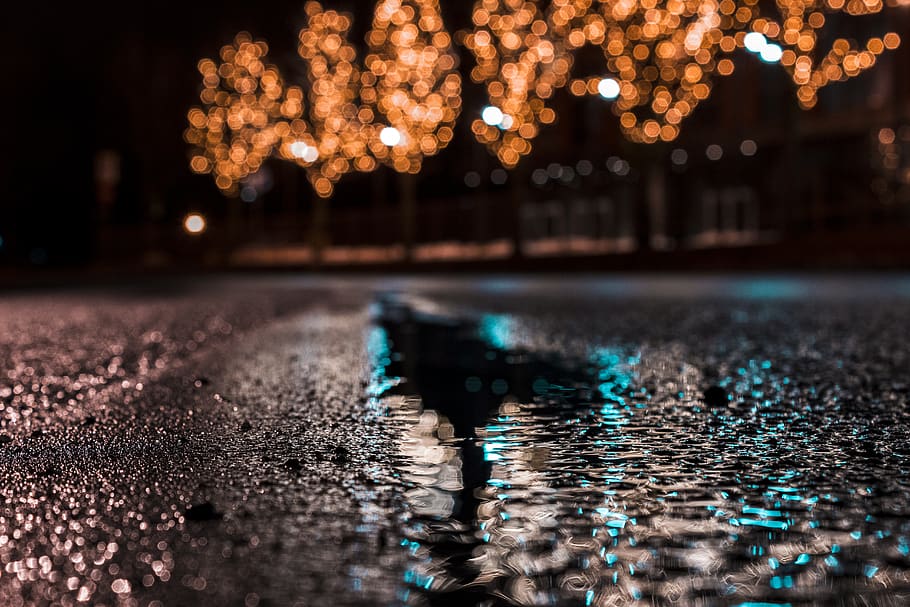 Selective Focus Photography of Asphalt Road With Water Droplets Near City Lights during Nighttime HD wallpaper