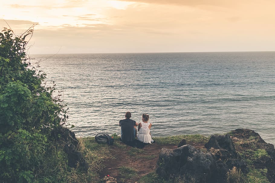 Man and Woman Sitting Near Body of Water, cliff, couple, daylight HD wallpaper